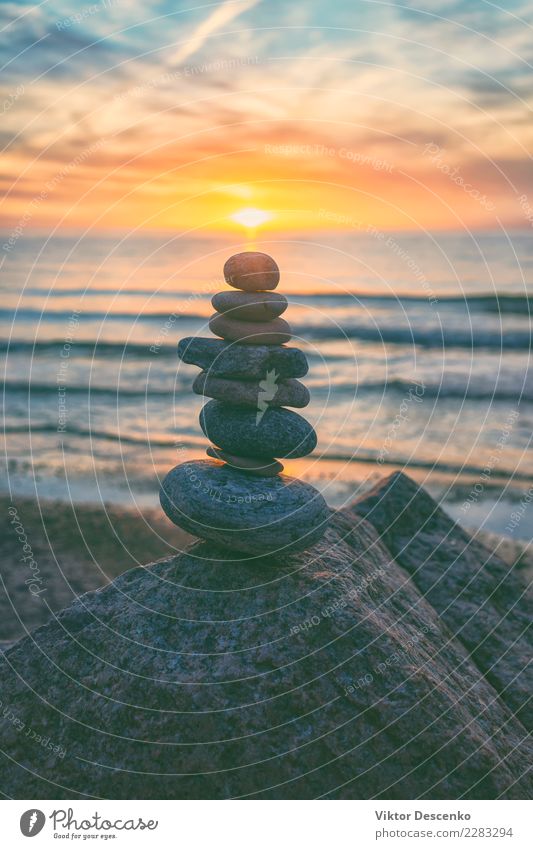 Pyramid of stones against the sunset Design Beautiful Harmonious Relaxation Meditation Spa Massage Summer Sun Beach Ocean Decoration Group Nature Landscape Sky