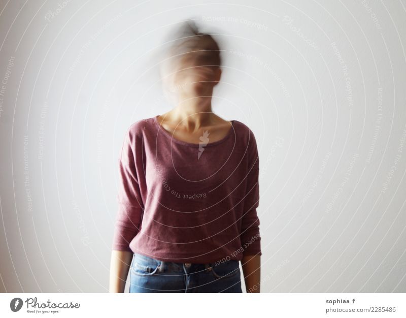 Who am I? Portrait of confused young woman with blurred face. She is moving her head fast, so her face isn't identifiable. Motion blur. who am i confusion