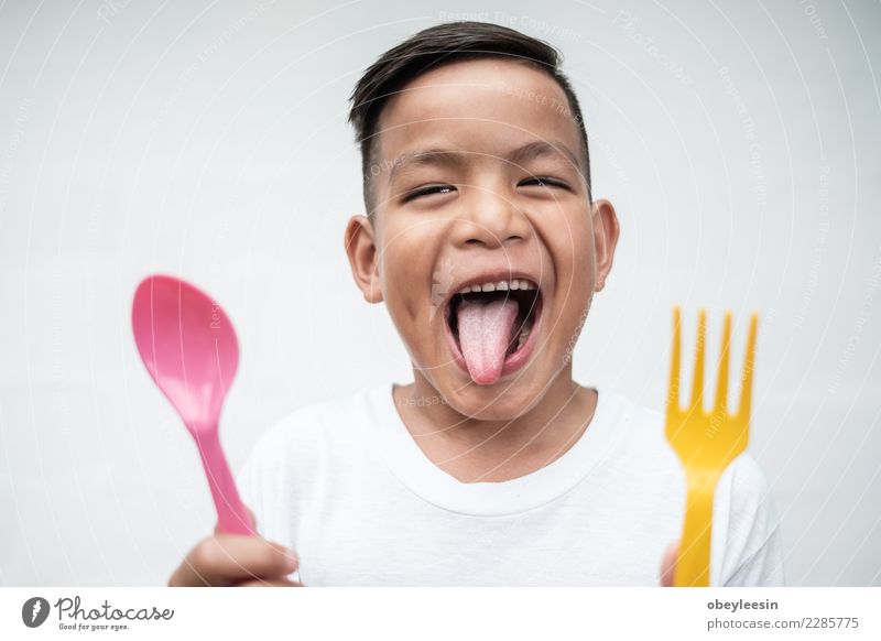 young asian boy with foek and spoon Vegetable Nutrition Eating Lunch Dinner Vegetarian diet Diet Bottle Lifestyle Happy Beautiful Face Leisure and hobbies Table