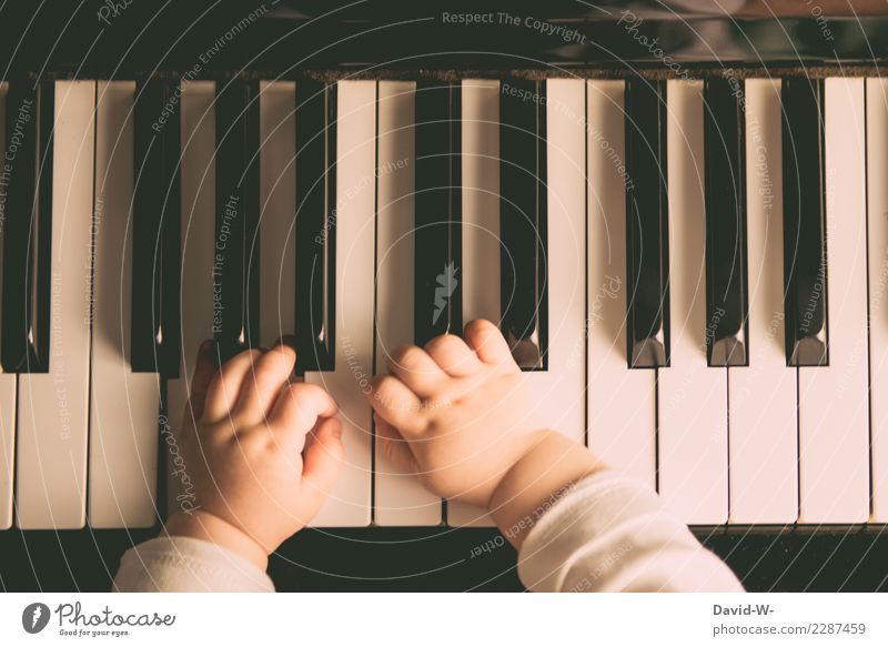 Toddler plays piano with delicate hands Piano early musical education Play piano Child Baby Cute beautifully Warm colour Wonderful Delicate Infancy