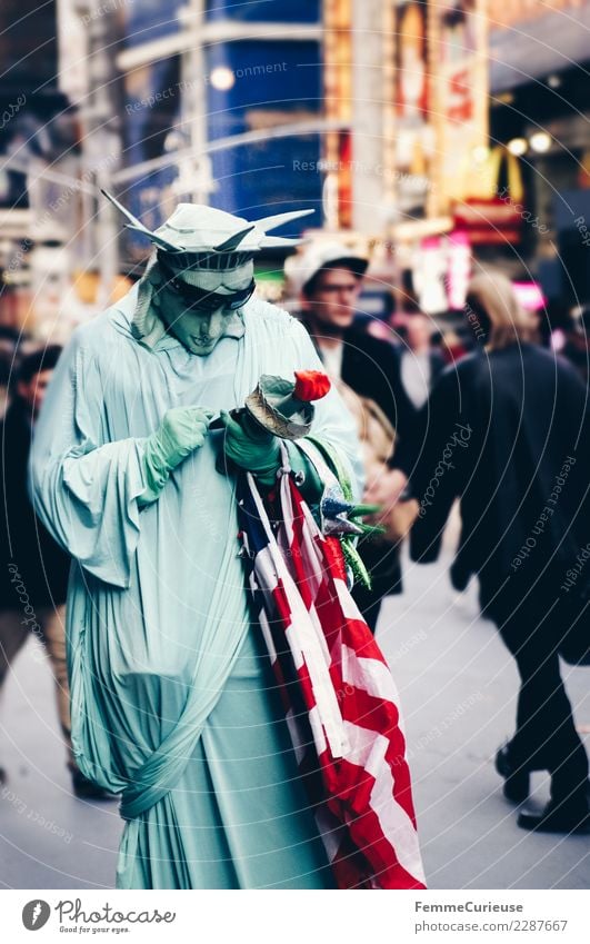 Person dressed as Statue of Liberty looking at mobile phone Sign Communicate Carnival costume Cellphone Computer network SMS Flag USA New York City Times Square
