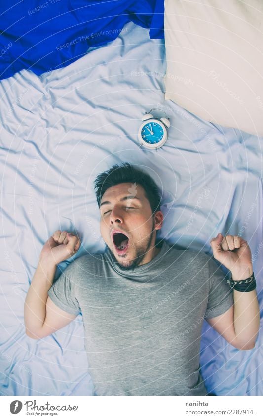 Young man yawning in his bed Lifestyle Senses Relaxation Clock Bed Bedroom Work and employment Human being Masculine Youth (Young adults) Man Adults 1