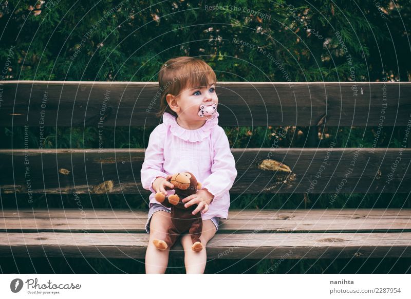 Lovely little girl sitting in a wooden bench Lifestyle Joy Wellness Relaxation Leisure and hobbies Children's game Human being Feminine Girl Infancy 1