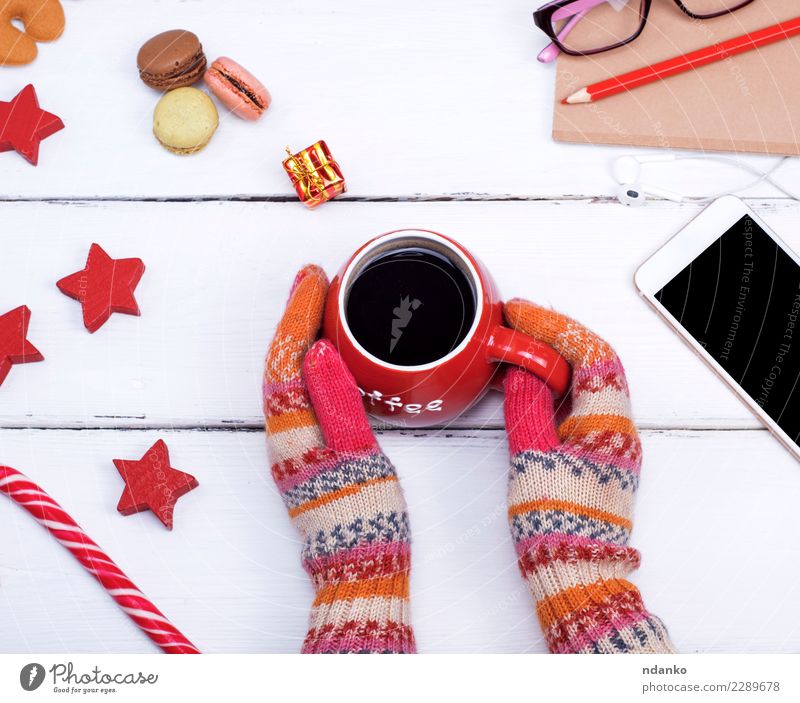 hands in knitted mittens hold a red cup Food Coffee Cup Body Winter Table Feasts & Celebrations Christmas & Advent Telephone PDA Woman Adults Hand Clothing Wood