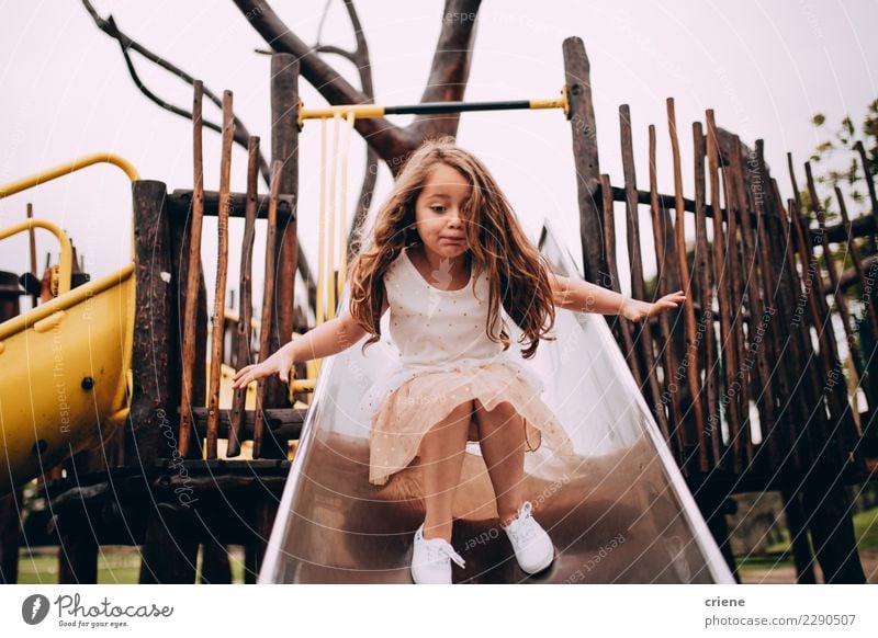 Little caucasian girl having fun on slide on playground Lifestyle Joy Happy Playing Child Infancy Playground Small Cute Emotions little girl cheerful young