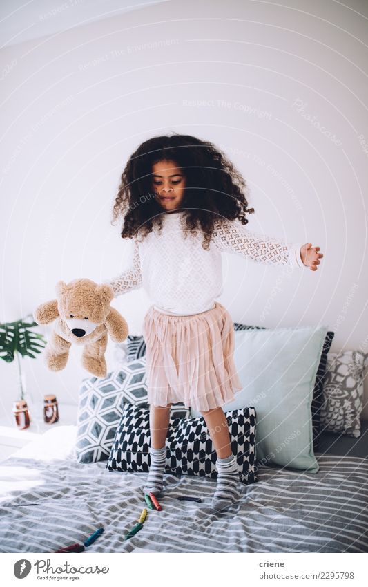 Little african girl sitting on bed with teddy bear smiling - a Royalty Free  Stock Photo from Photocase