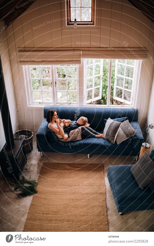 Caucasian mother and toddler boy cuddle together on couch Lifestyle Joy Happy House (Residential Structure) Child Boy (child) Woman Adults Parents Mother