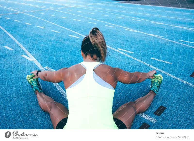 Female athletes running in competition on blue track - Stock Image