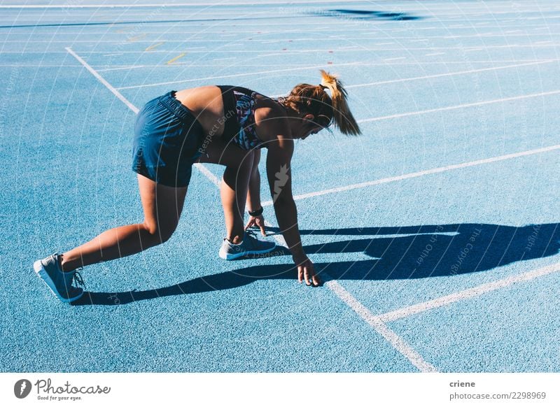 Fit woman practicing for marathon on blue running track Lifestyle Sports Track and Field Success Stadium Human being Woman Adults Footwear Fitness Blue