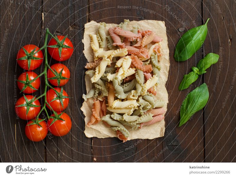 Tricolor pasta, tomatoes and basil on a wooden background Vegetarian diet Diet Table Dark Fresh Brown Red Tradition cooking food health healthy Ingredients