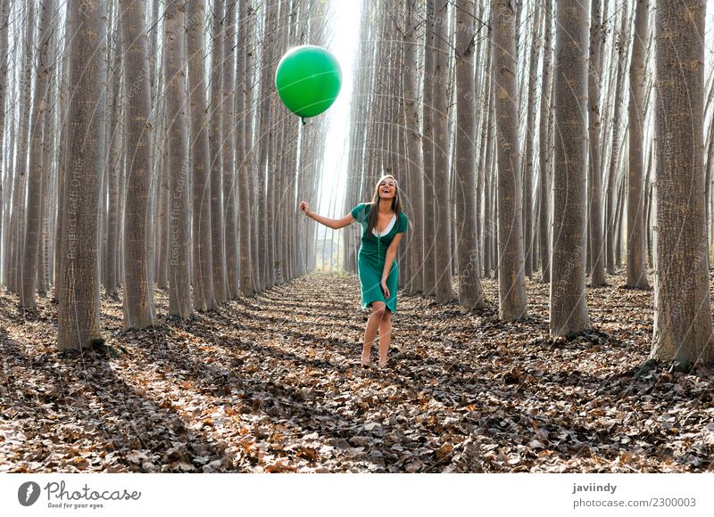 Girl laughing in the forest with green balloon and dress Joy Human being Young woman Youth (Young adults) Woman Adults 1 18 - 30 years Nature Autumn Tree Leaf
