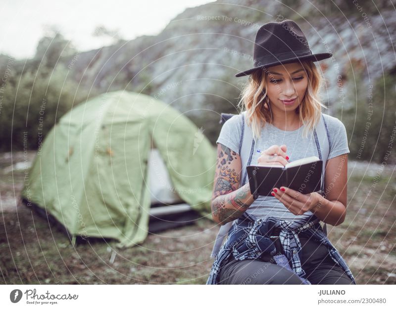 Young woman taking notes in the nature Lifestyle Vacation & Travel Trip Adventure Far-off places Freedom Camping Mountain Hiking Human being Couple Partner