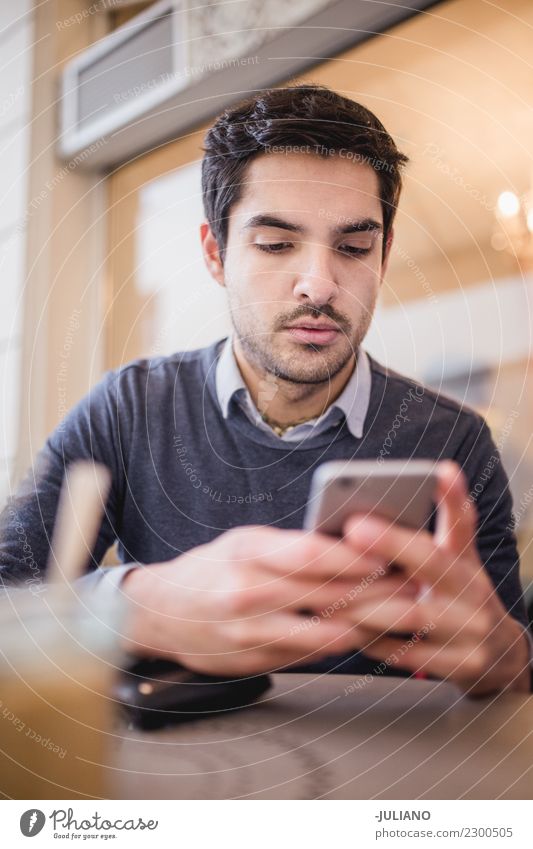 Young man at cafe looking at his phone Breakfast To have a coffee Communicate Lifestyle Shopping Leisure and hobbies PDA Human being Masculine