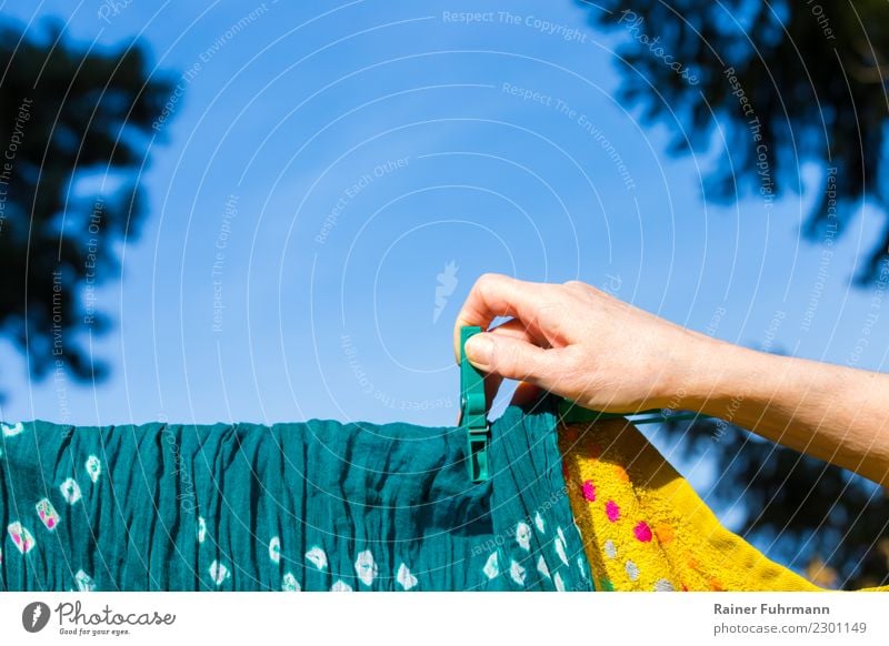 a woman hangs laundry to dry on a clothesline Flat (apartment) Garden Human being Feminine Hand Cleanliness Purity "wash Laundry housework role distribution