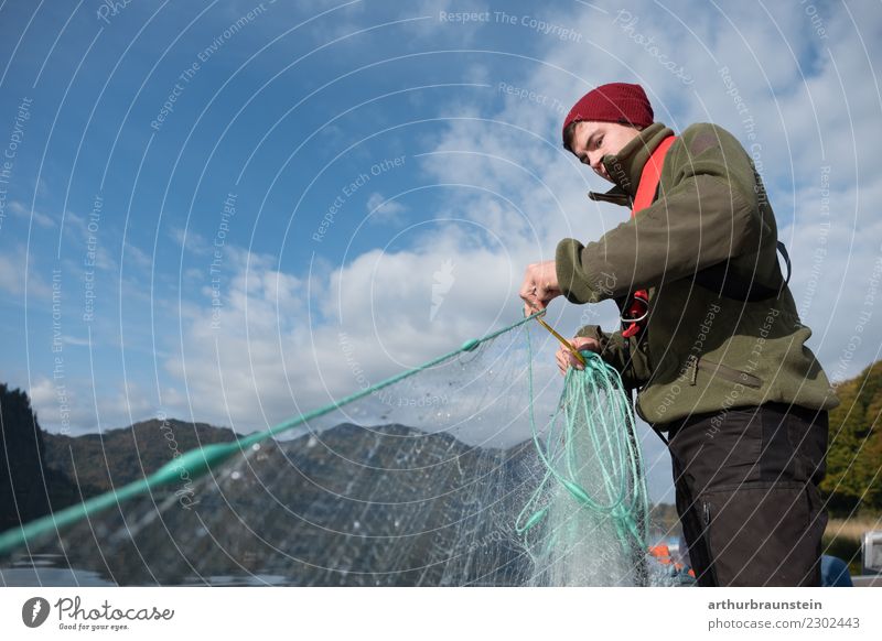 Young fisherman pulls in his fishing net youthful Fisherman Man Lake Water Blue sky Fishing net hobby Beautiful weather sunny teaching profession Apprentice