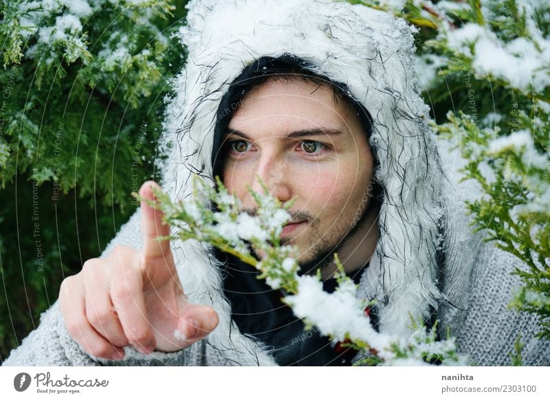 Young man touching a snowy branch Lifestyle Style Human being Masculine Youth (Young adults) Man Adults 1 30 - 45 years Environment Nature Winter Climate