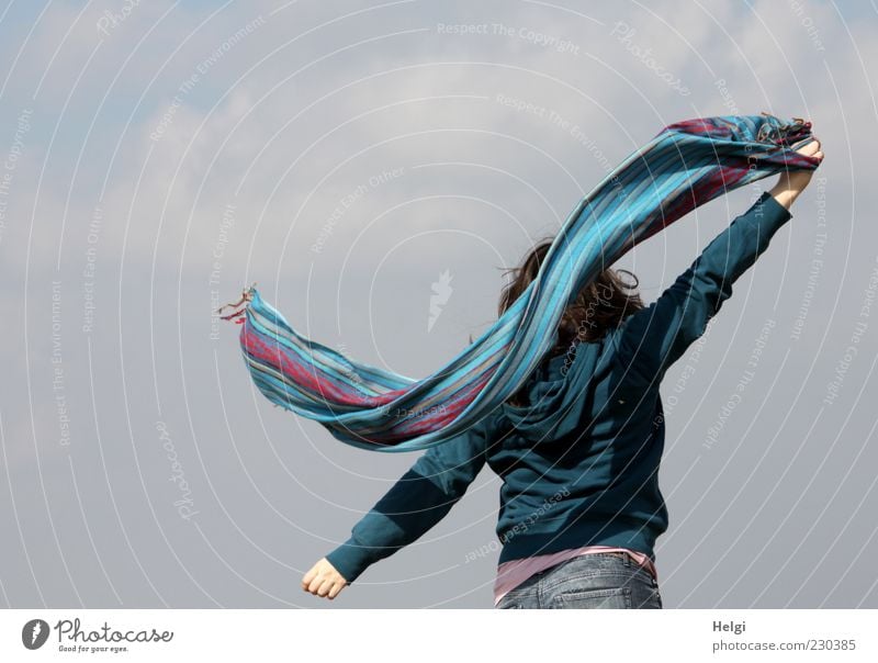 Rear view of a young woman swinging a colourful scarf in front of a grey sky Joy Life Well-being Contentment Leisure and hobbies Freedom Human being Feminine