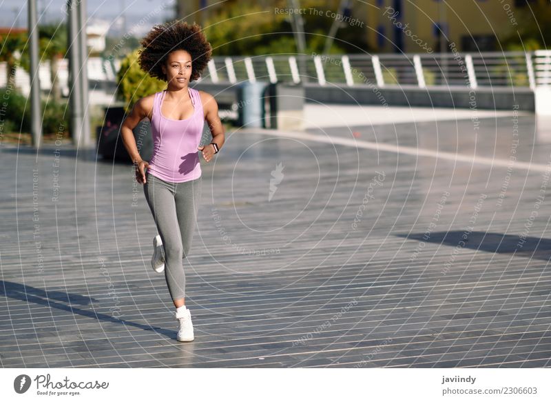 Black woman, afro hairstyle, running outdoors in urban road. Lifestyle Beautiful Hair and hairstyles Wellness Leisure and hobbies Sports Jogging Human being