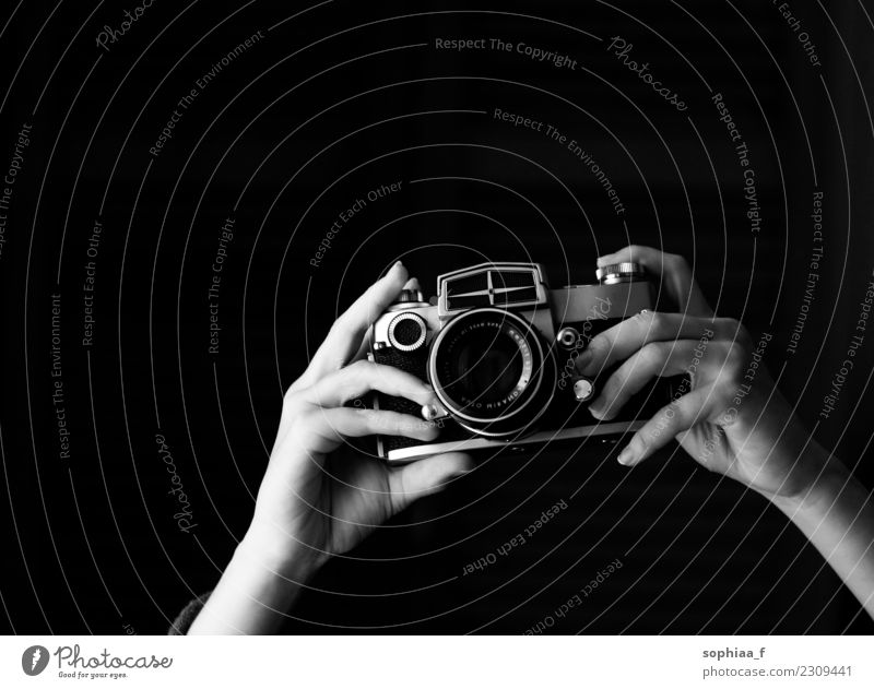 hands holding old analogue camera, taking photos taking pictures retro focus vintage shot equipment click black and white black background photographing