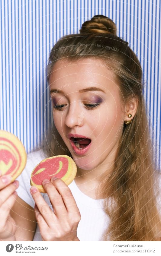 Young woman eating 2 cookies. Feminine Youth (Young adults) Woman Adults 1 Human being 18 - 30 years To enjoy Nutrition Butter cookie Cookie Anticipation Candy