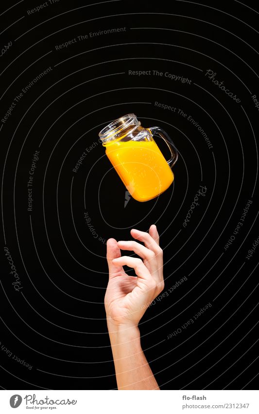 ONE HAND REACHES FROM BELOW FOR A GLASS OF YELLOW FLUID Food Fruit Orange Breakfast Organic produce Vegetarian diet Diet Fasting Beverage Lemonade Juice