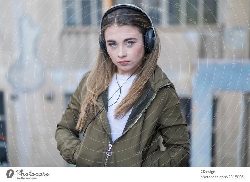 Young girl with headphones standing on the street Lifestyle Joy Happy Beautiful Relaxation Leisure and hobbies Music Technology Human being Woman Adults