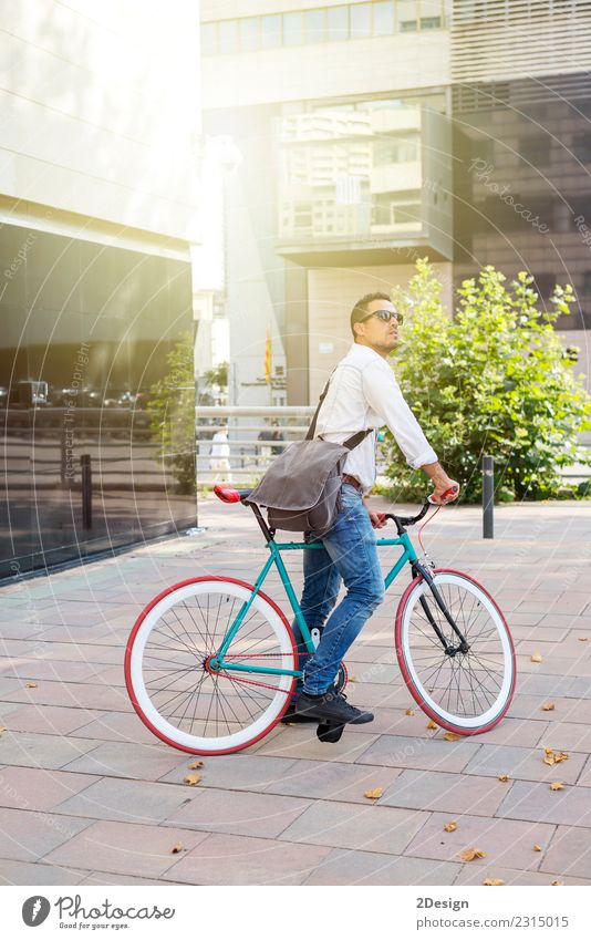 A young stylish man posing next to his bicycle. Relaxation Sports Man Adults Youth (Young adults) Youth culture Street Fashion Jeans Eyeglasses