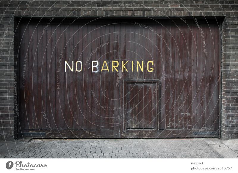 Note on a garage door Town Capital city Downtown House (Residential Structure) Places Parking garage Street Road sign Brown Garage door Parking lot