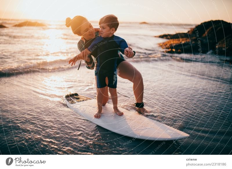 Little boy and mother practicing surfing at beach Lifestyle Joy Happy Relaxation Leisure and hobbies Vacation & Travel Summer Beach Ocean Sports Child School