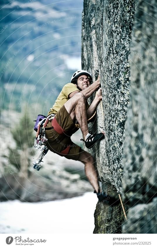 Rock climber clinging to a cliff. - a Royalty Free Stock Photo