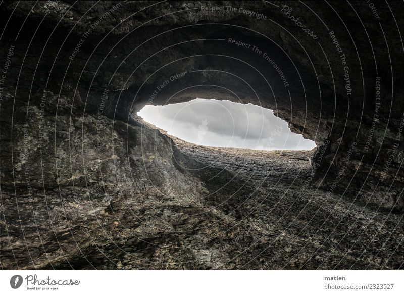 hole Nature Landscape Clouds Bad weather Rock Dark Brown Gray Cave Open Hollow Opening Colour photo Exterior shot Pattern Structures and shapes Deserted