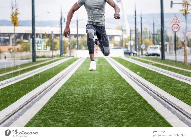 Black man jumping in urban background. Lifestyle Sports Jogging Human being Masculine Young man Youth (Young adults) Man Adults 1 18 - 30 years Street Fitness