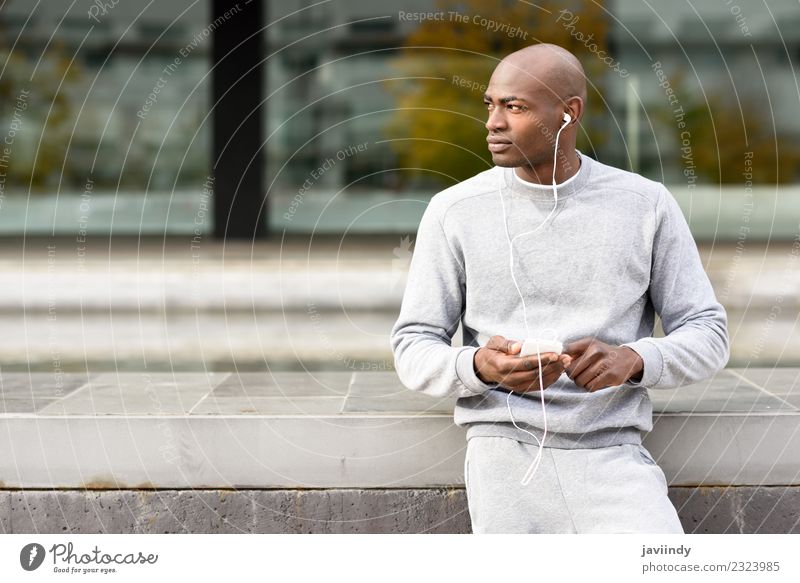 Attractive black man listening to music with headphones outdoors Lifestyle Happy Music Sports Telephone PDA Technology Human being Young man