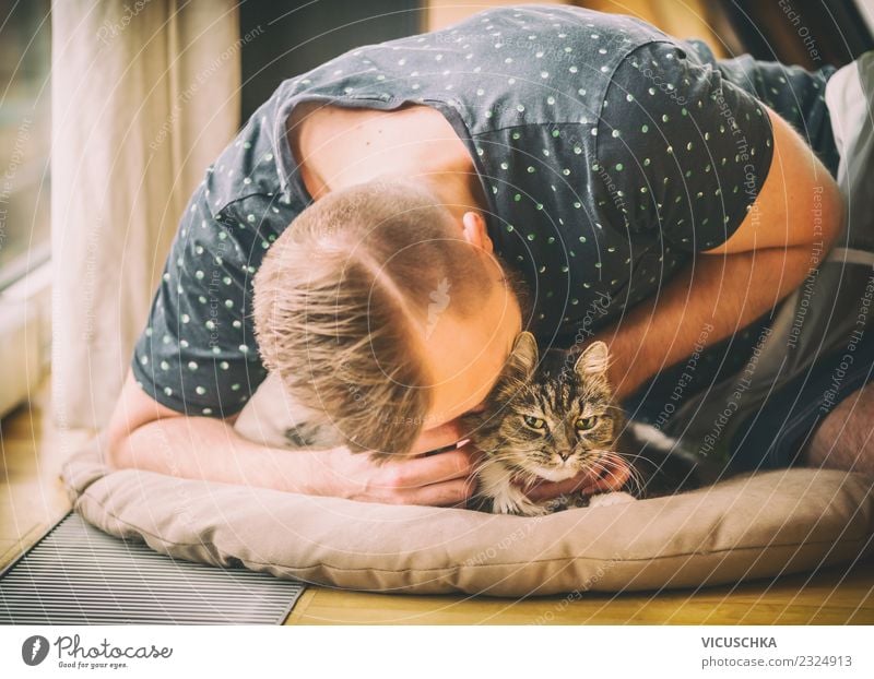 Man cuddles with cat Lifestyle Joy Living or residing Flat (apartment) Human being Young man Youth (Young adults) Adults Animal Pet Cat Love Yellow Emotions