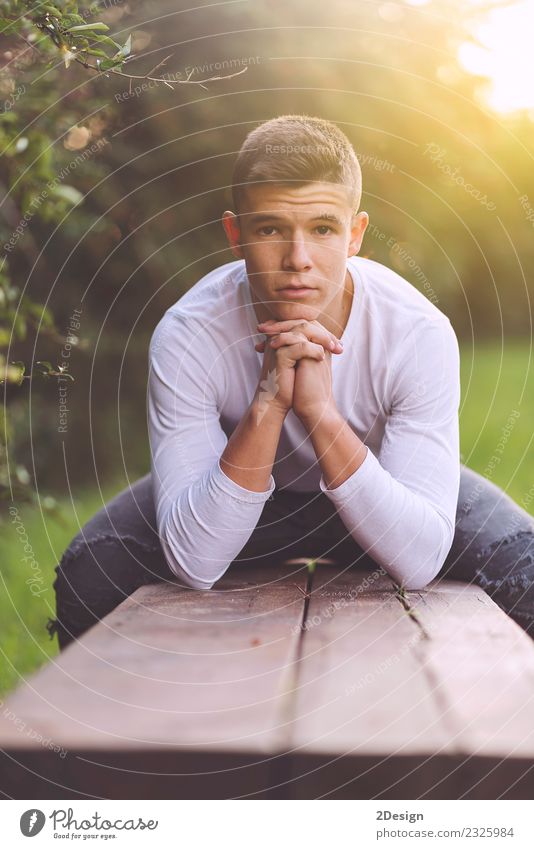 Stylish teenager sitting on a wooden bench Lifestyle Happy Schoolchild Academic studies PDA Human being Boy (child) Man Adults Youth (Young adults) Autumn Park