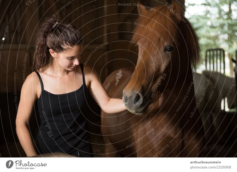Young dark-haired curly woman with horse in stable Leisure and hobbies Ride Equestrian sports Riding school Vacation & Travel Trip Riding stable Riding hall