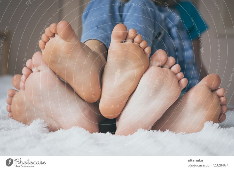 Happy children sitting on the bed barefoot. Lifestyle Joy Relaxation Bedroom Child Human being Baby Boy (child) Woman Adults Man Sister Family & Relations