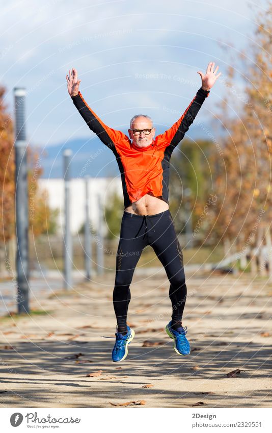 Senior runner man jumping arms up after running Lifestyle Joy Happy Body Healthy Leisure and hobbies Sports Track and Field Sportsperson Success Jogging