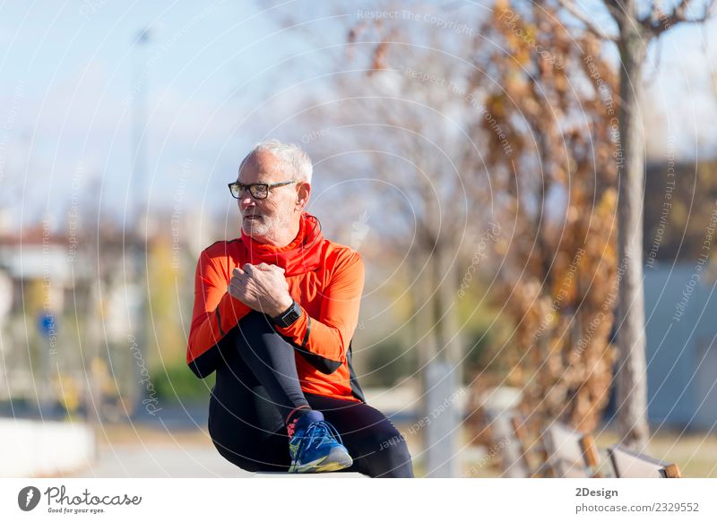 Senior runner man sitting after jogging in a park Lifestyle Happy Healthy Athletic Relaxation Calm Leisure and hobbies Summer Music Sports Track and Field