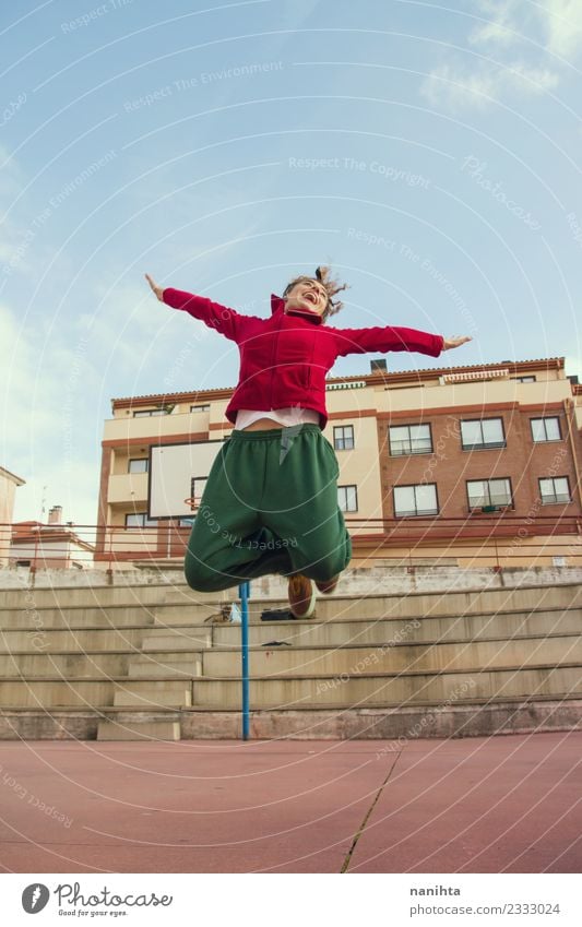 Young happy woman jumping in the street Lifestyle Style Joy Healthy Athletic Fitness Wellness Sports Sports Training Track and Field Human being Feminine
