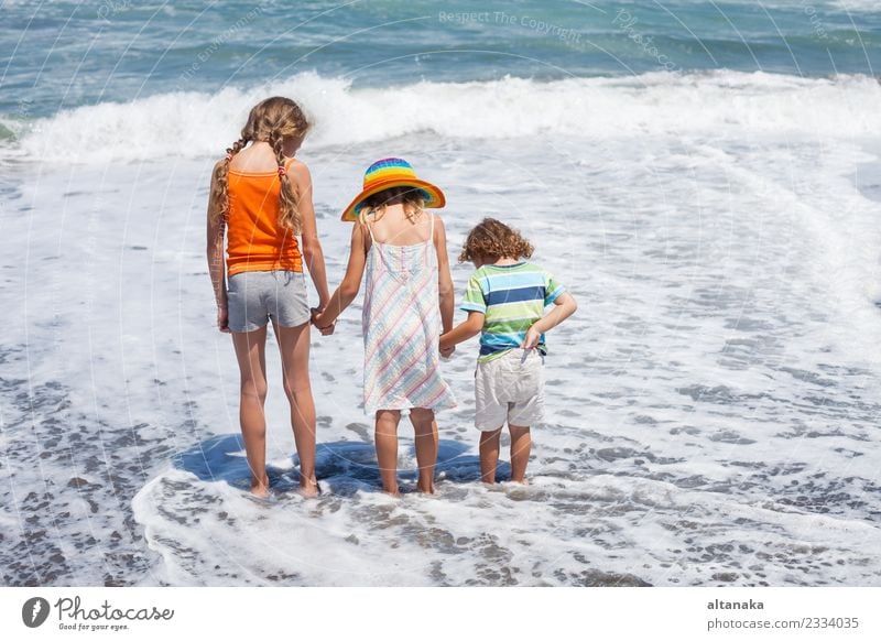 Three happy children playing on the beach at the day time. Concept of summer vacation. Lifestyle Joy Happy Beautiful Leisure and hobbies Playing