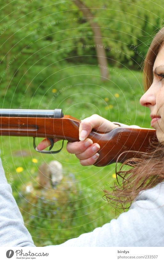 Attractive young woman with a rifle at the ready aims at her target and has her finger on the trigger Hunting Young woman Youth (Young adults) Face 1