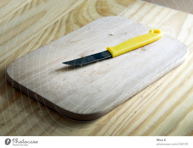 chopping board Cutlery Knives Yellow Chopping board Wooden board Wooden table Kitchen Table Colour photo Interior shot Close-up Structures and shapes Deserted