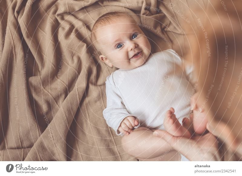 mom dresses the baby on the bed Lifestyle Joy Happy Beautiful Playing Bedroom Parenting Child Baby Boy (child) Woman Adults Parents Mother Family & Relations