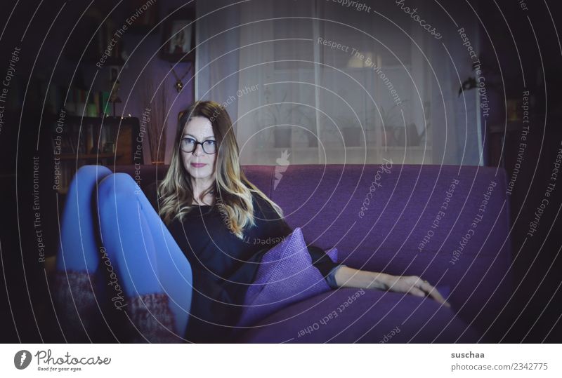 woman at home on the purple sofa Woman Young woman 1 Person Person wearing glasses Sofa Sit Living or residing Flat (apartment) domestic Cozy Winter dark season