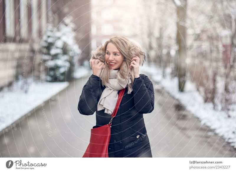 Smiling young woman walking along a snowy road Happy Beautiful Winter Snow Woman Adults 1 Human being 45 - 60 years Nature Weather Street Fashion Jacket Coat