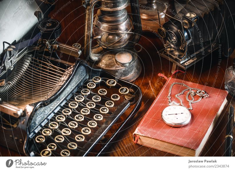 Traditional and old way of writing messages and taking photos, typewriter, camera, watch, pen, Vintage lamp on the desk White ancient antique background black