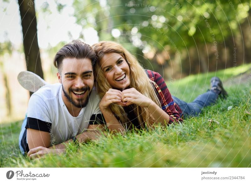 Beautiful young couple laying on grass in an urban park Lifestyle Joy Happy Summer Human being Young woman Youth (Young adults) Young man Woman Adults Man