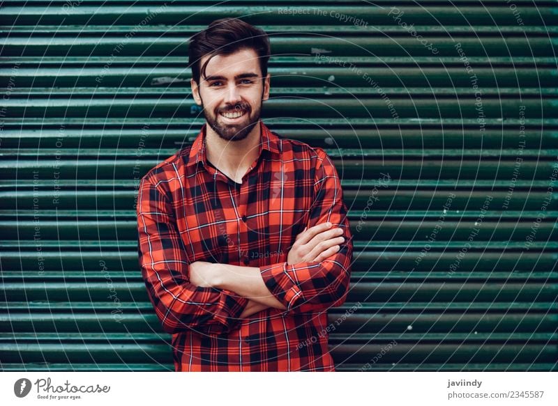 Positive male teenager wit dressed in street style clothes red