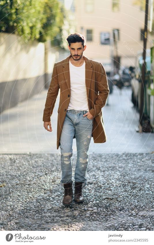 Young man wearing winter clothes in the street. Stock Photo by